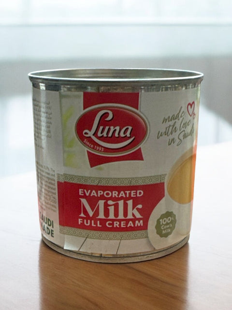 a can of milk sitting on top of a wooden table