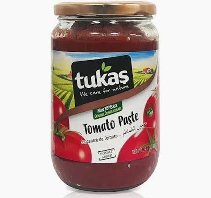 Jar of Tukas Premium Turkish Tomato Paste, 24.7 ounces, featuring a label with tomatoes and the slogan 'We care for nature.' The jar showcases a vibrant red tomato paste inside, emphasizing quality ingredients.